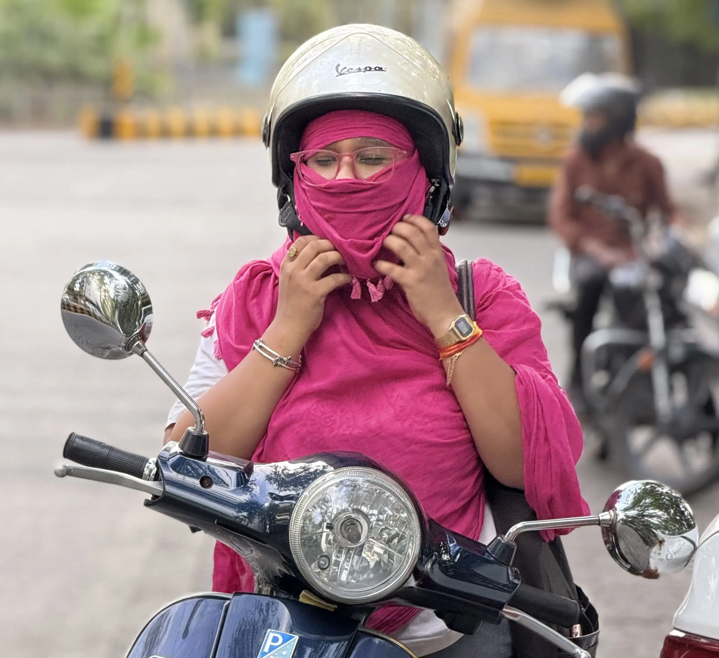 Traditional dupatta wrapped over the face — borrowed protection that slips and needs constant adjustment